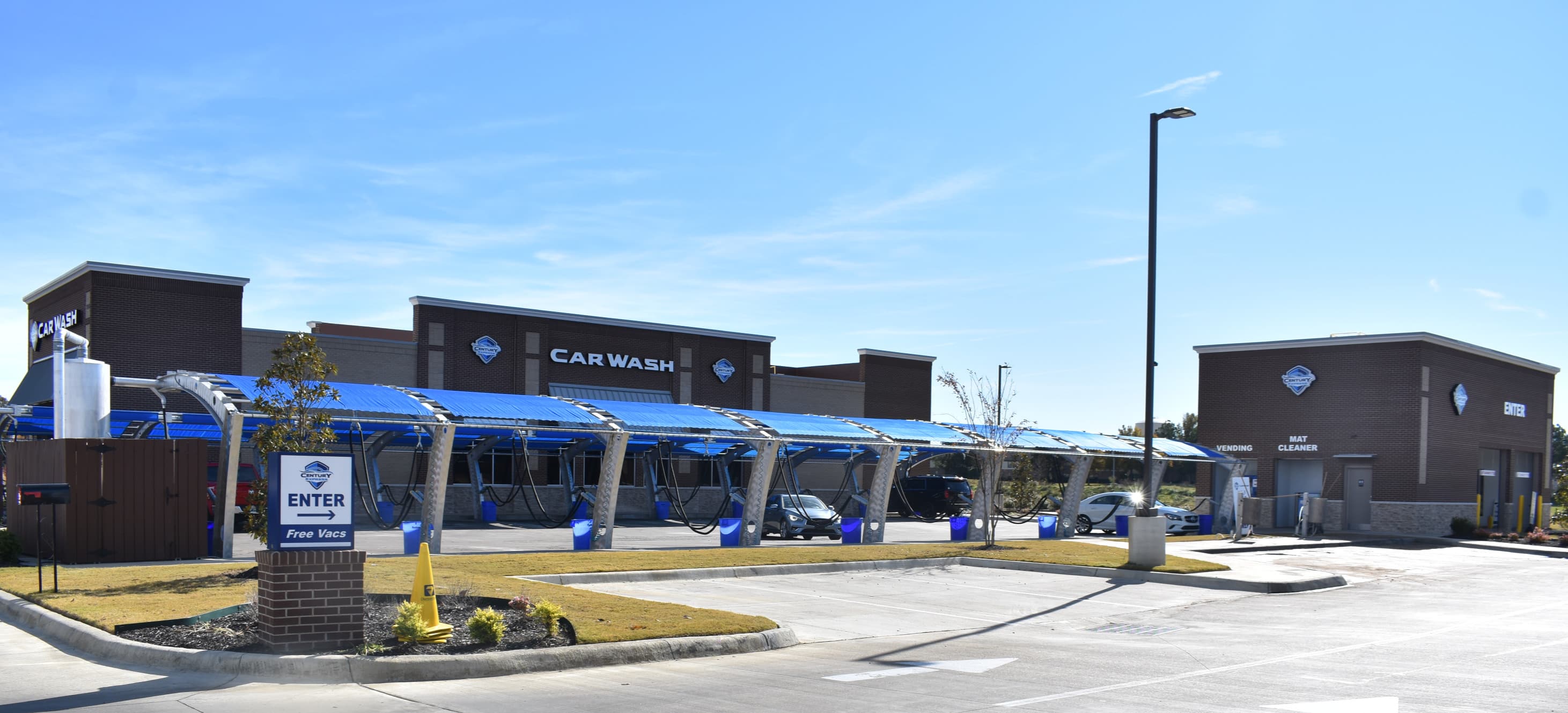 A Century Express Carwash site, with covered vacuum stalls and the wash tunnel